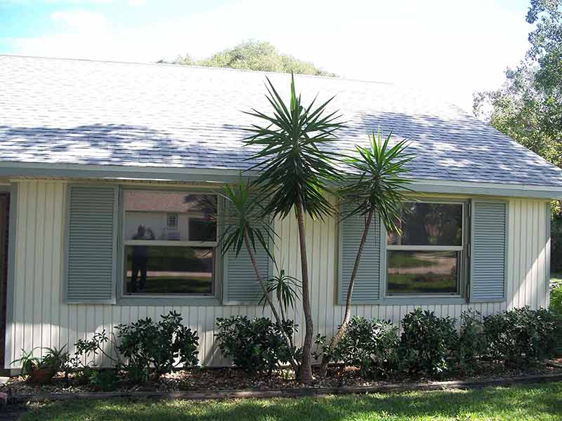 White Residential House with Colonial Shutter Installed — hurricane shutters Ormond Beach FL in Ormond Beach, FL