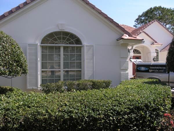 Colonial shutter in a white house — hurricane shutters Ormond Beach FL in Ormond Beach, FL