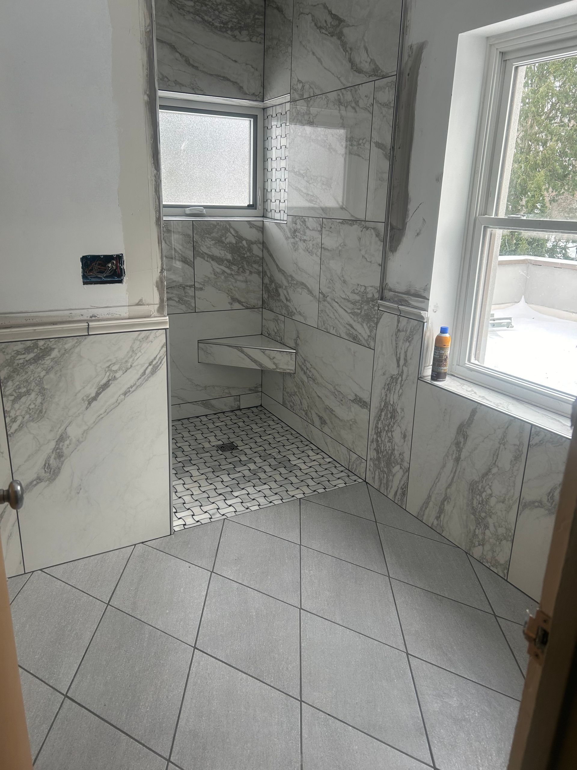 A bathroom with marble tiles and a window