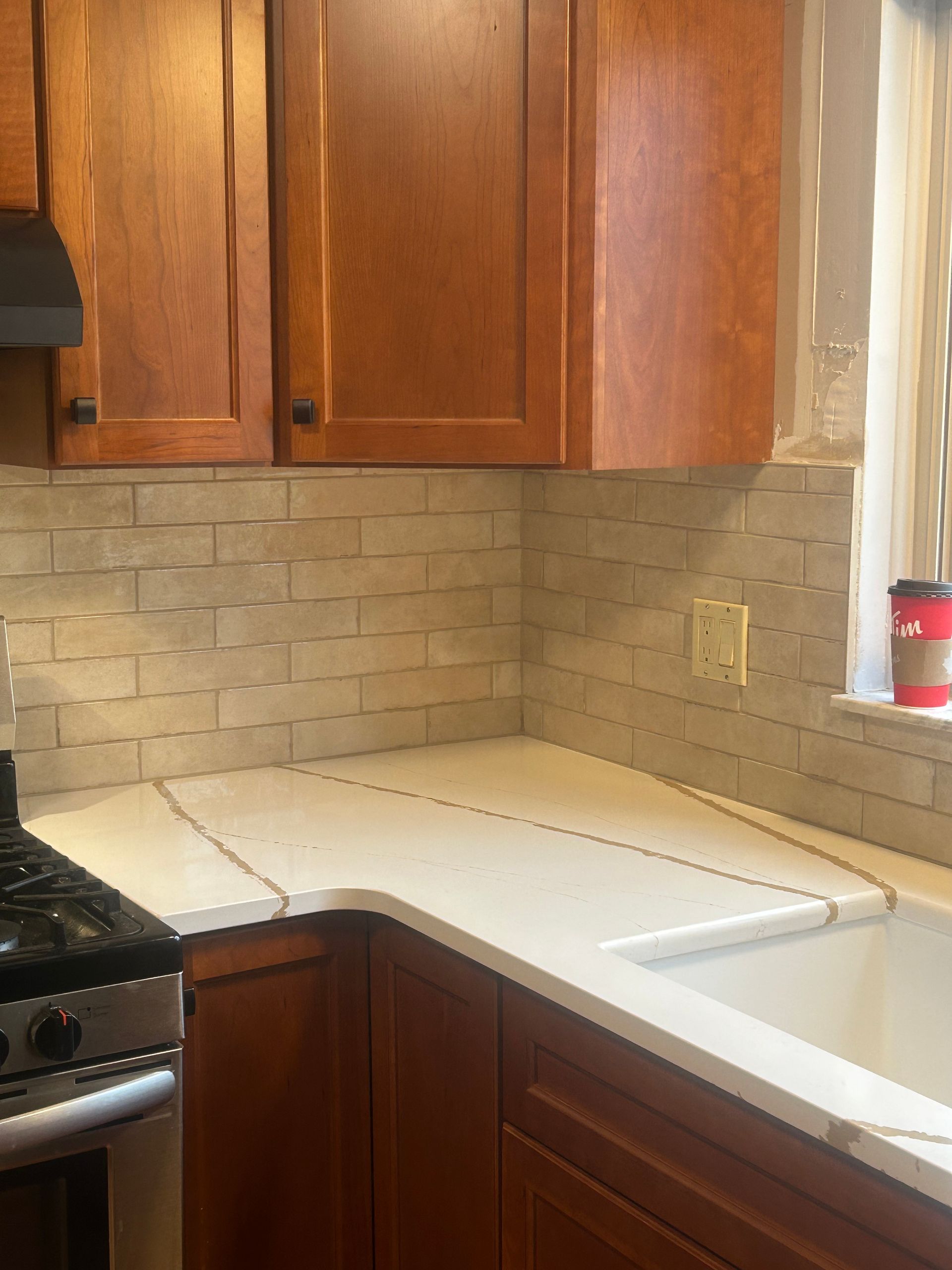 A kitchen with wooden cabinets and a stove and sink