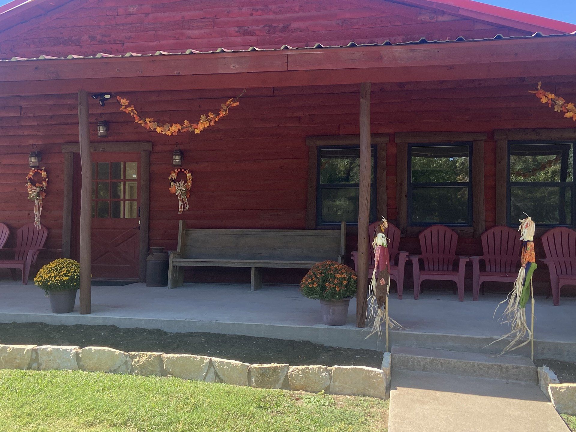 A red log cabin with a porch decorated for halloween