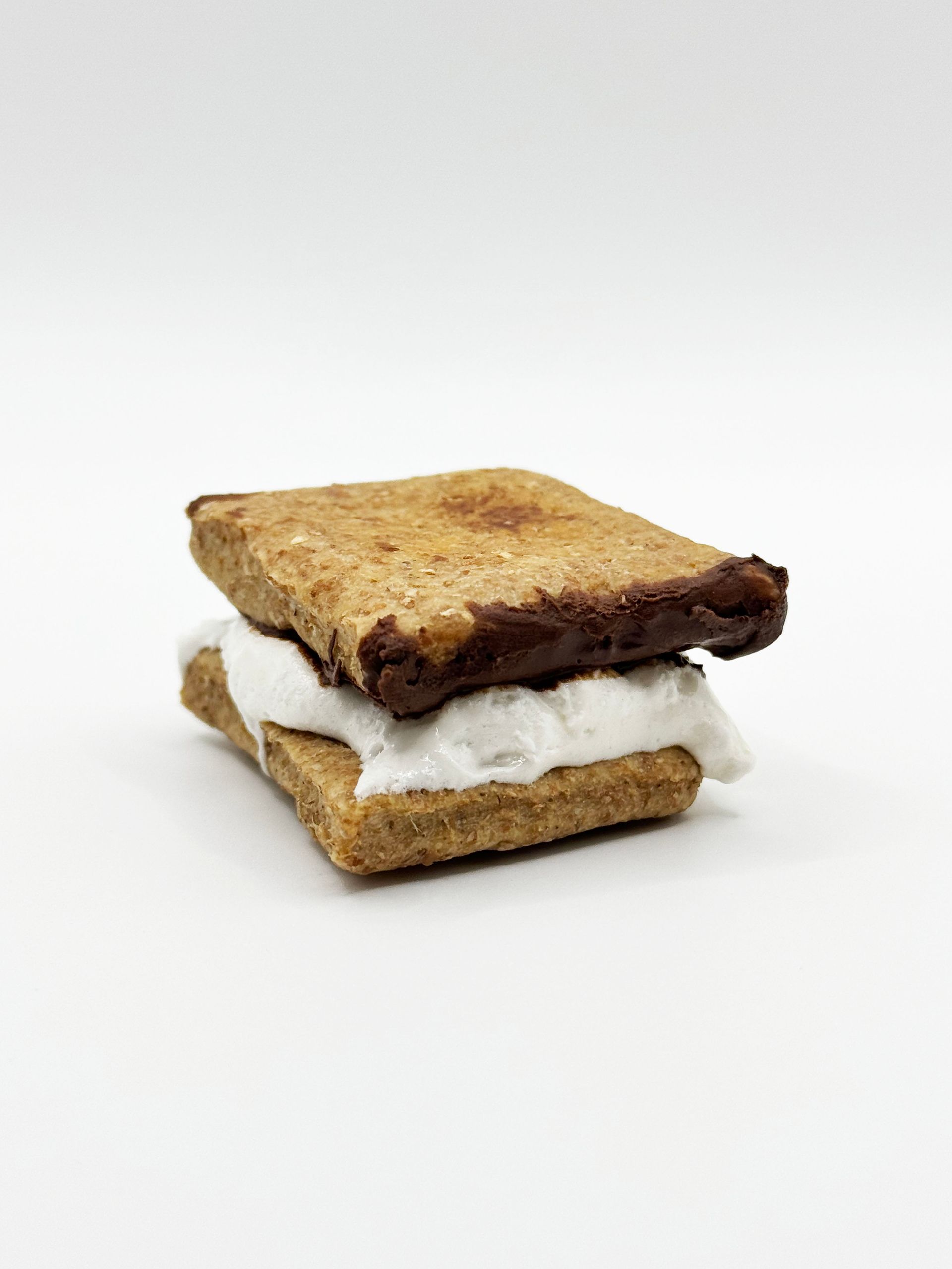 A s'more dog treat with carub and yogurt on a peanut butter treat.