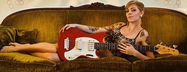 Image contains guitar, woman, couch