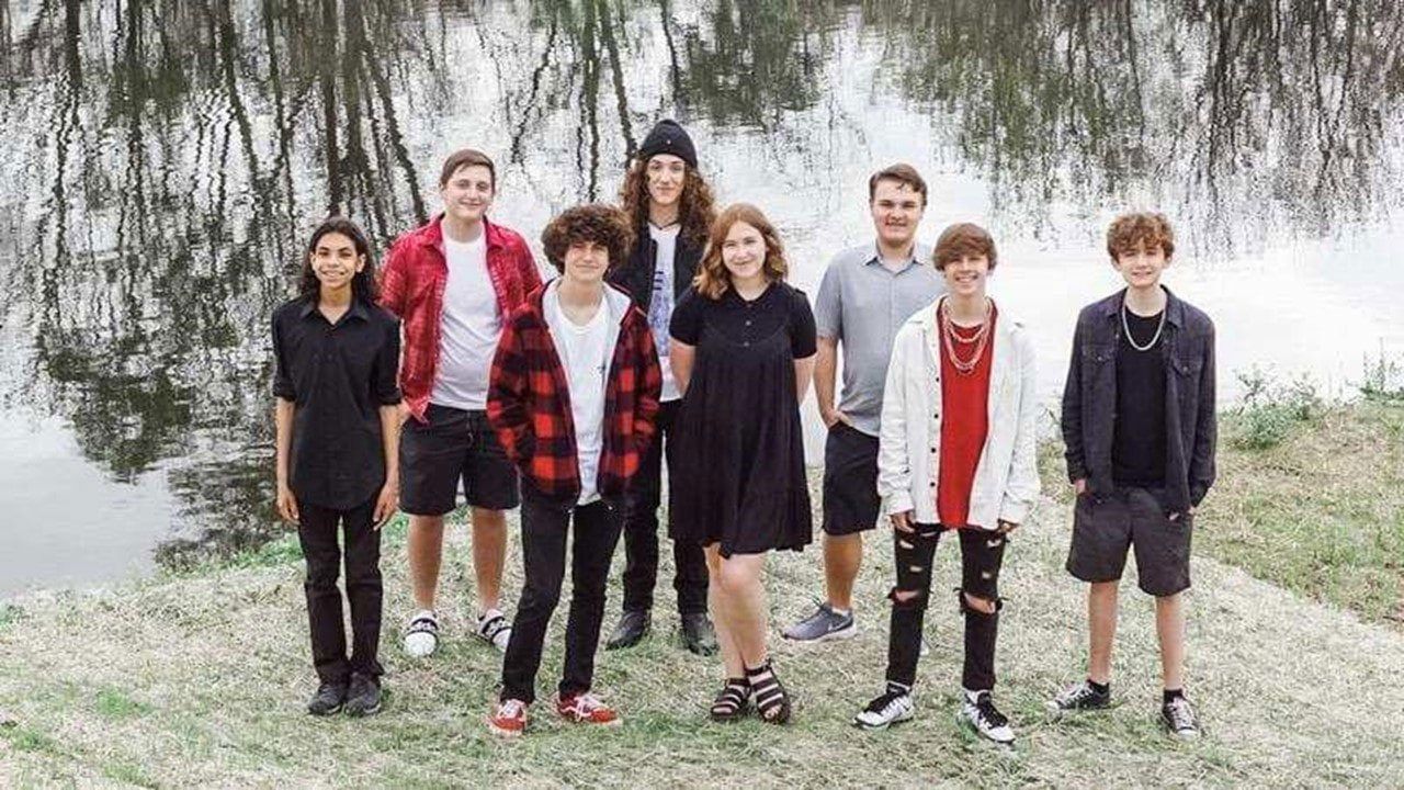 Image may contain group young people, lake, grass