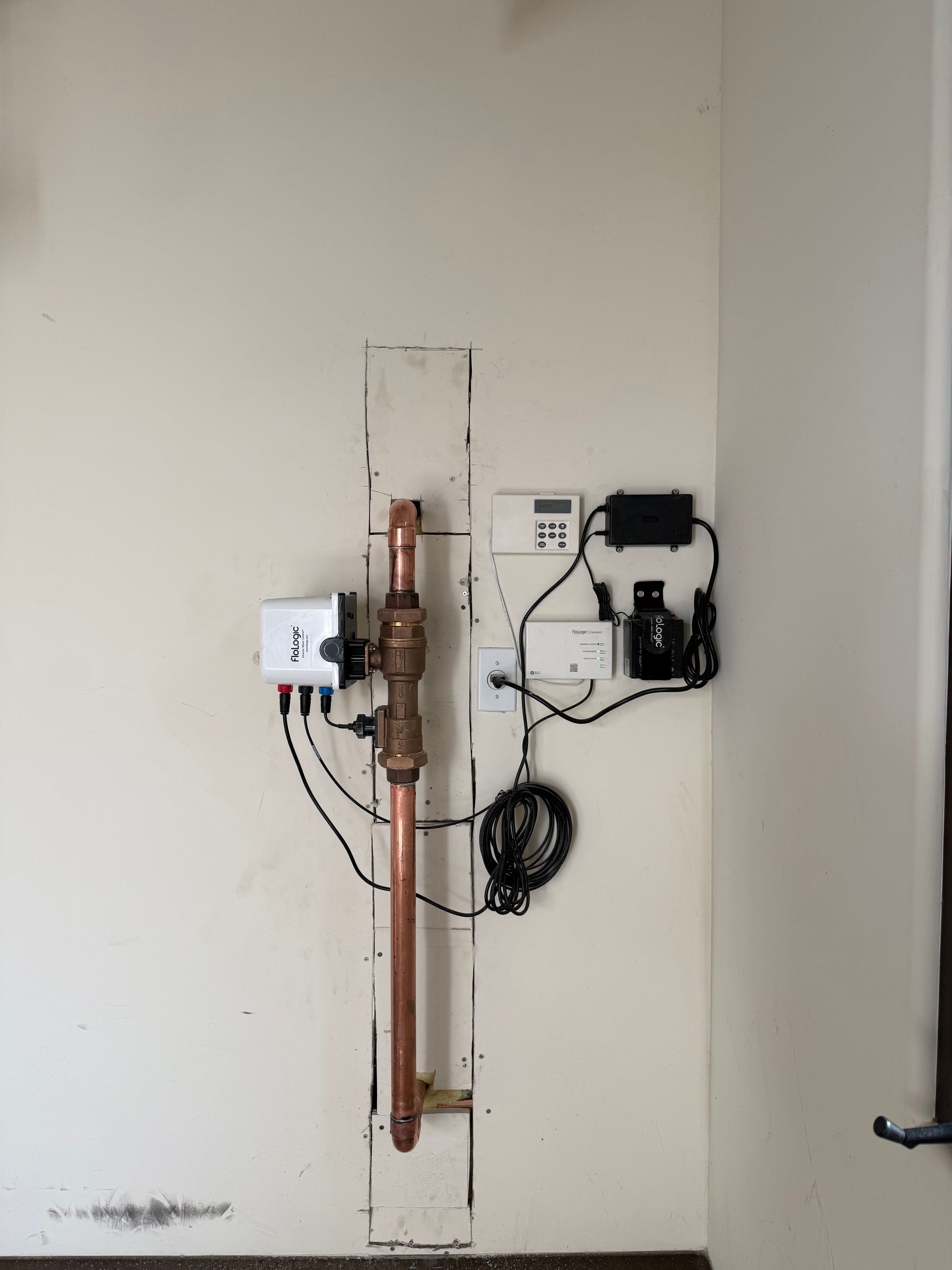 Plumber in red gloves working on toilet installation in a bathroom, wearing a cap and overalls.