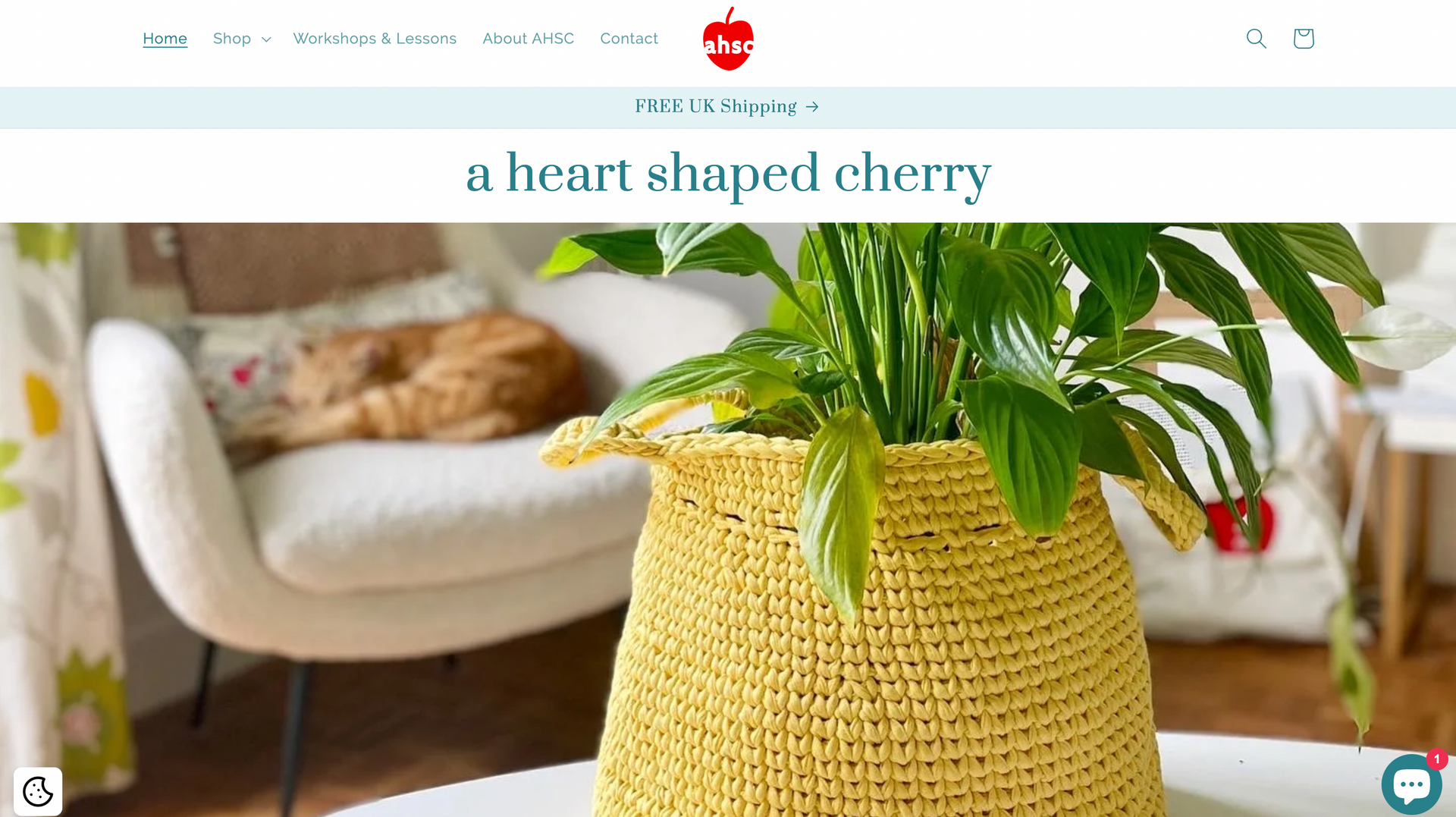 A heart shaped cherry website with a picture of a mustard basket with a plant in it and a cat on a chair