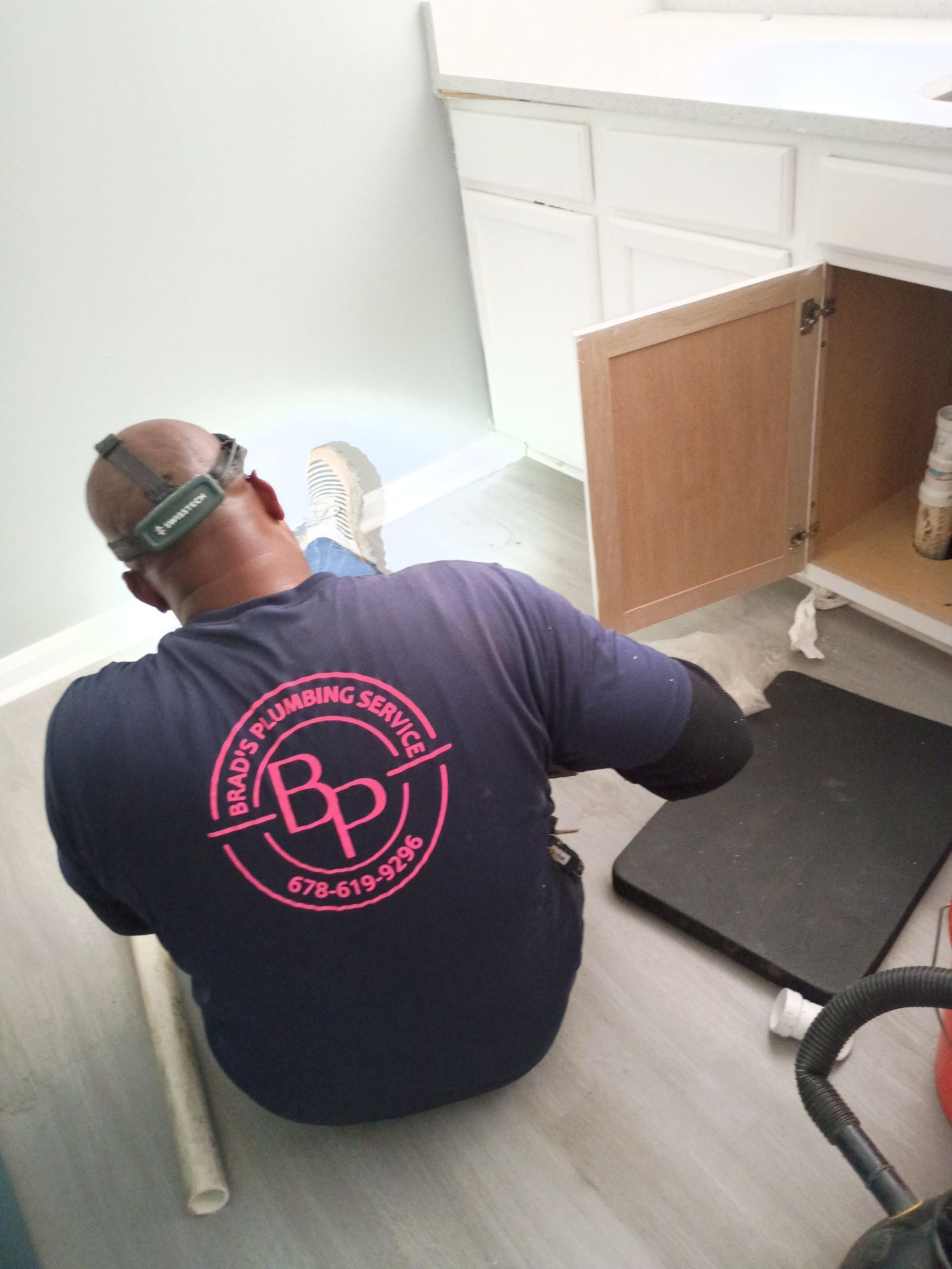 White van with plumbing service logo and contact information.