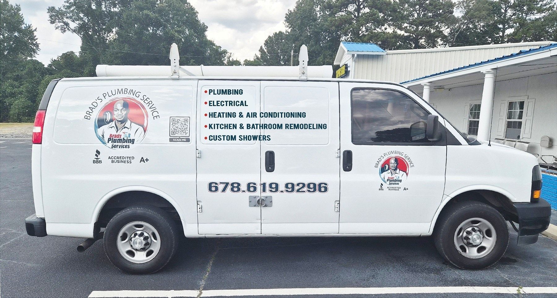 White service van with company logo parked outside a building, contact number visible.