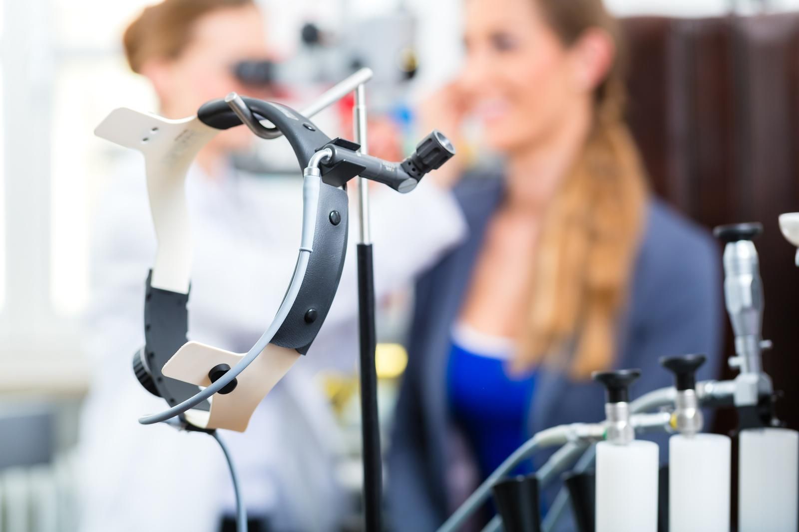 A woman is getting her ears examined by a doctor