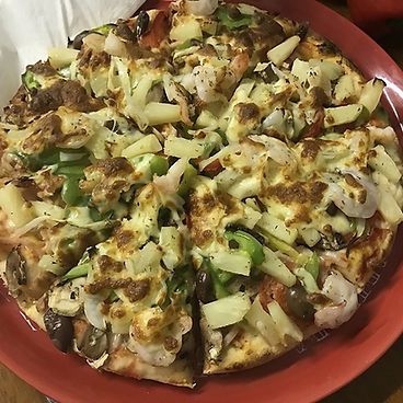 A Pizza With A Lot Of Toppings On It Is On A Red Plate — Bel-Air Pizza In Port Macquarie, NSW