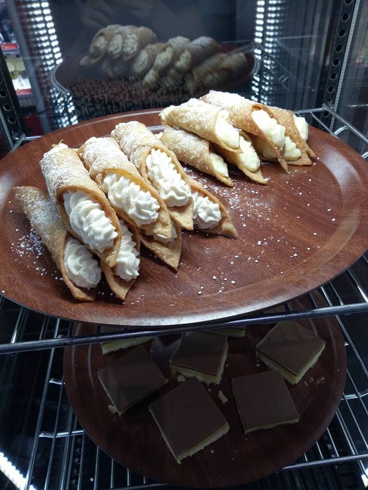 A Wooden Tray Filled With Cannoli And Chocolate Squares — Bel-Air Pizza In Port Macquarie, NSW