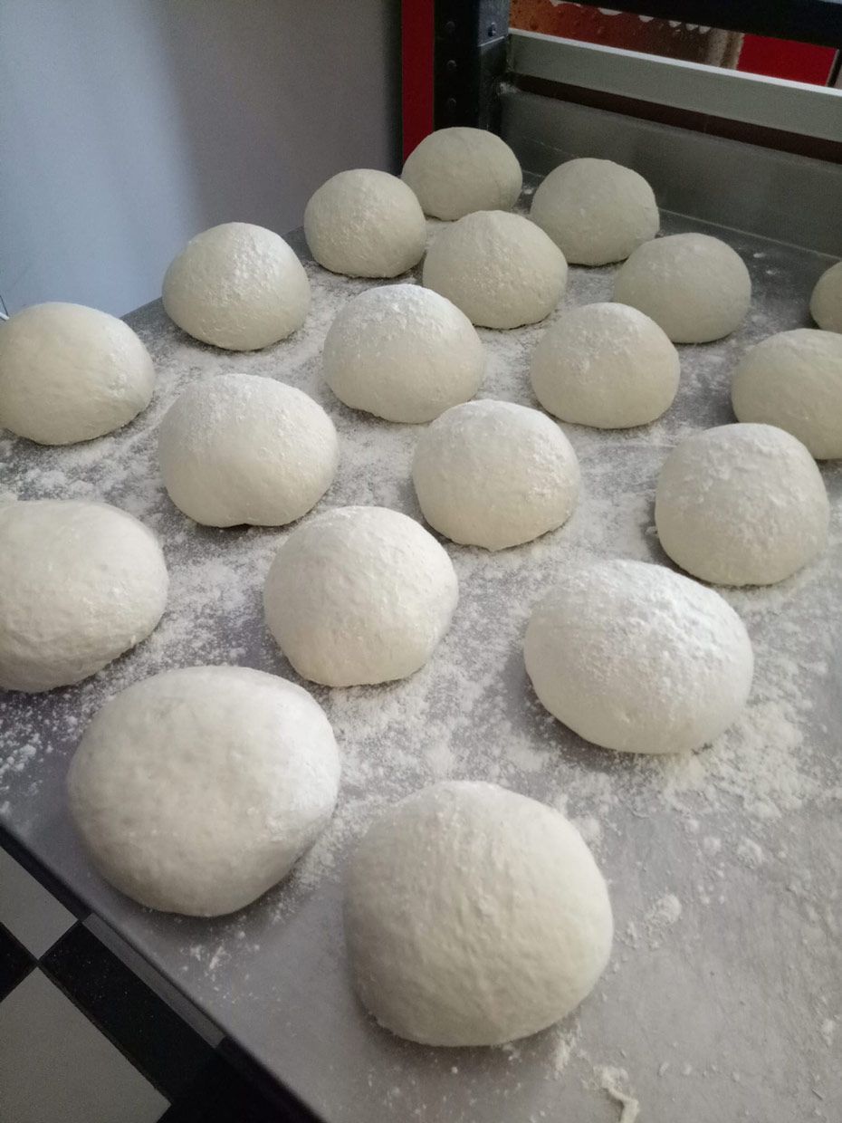 A Bunch Of Dough Balls Are Sitting On A Table — Bel-Air Pizza In Port Macquarie, NSW
