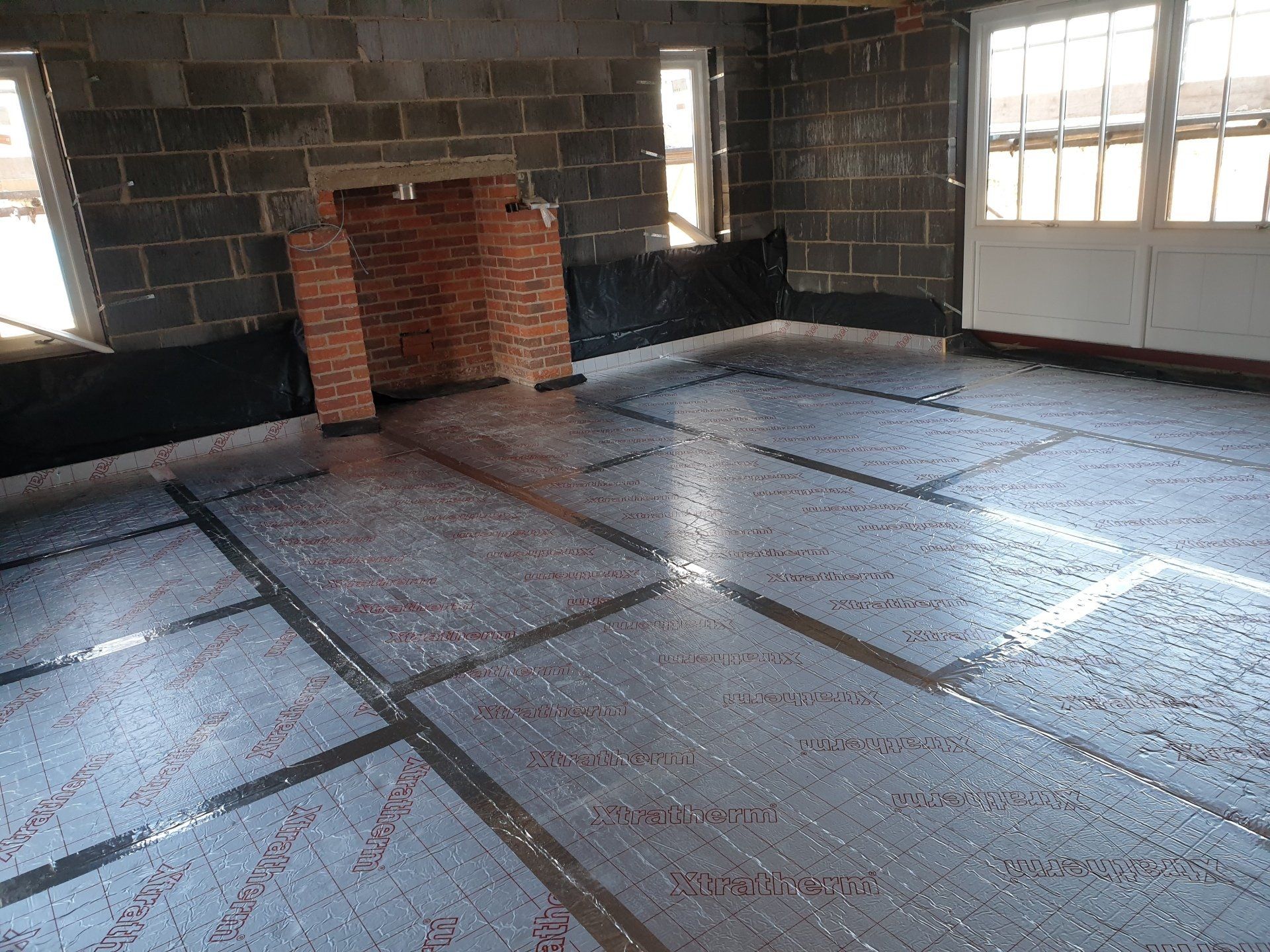 Floor insulation installed correctly with foil tape over all of the joints.