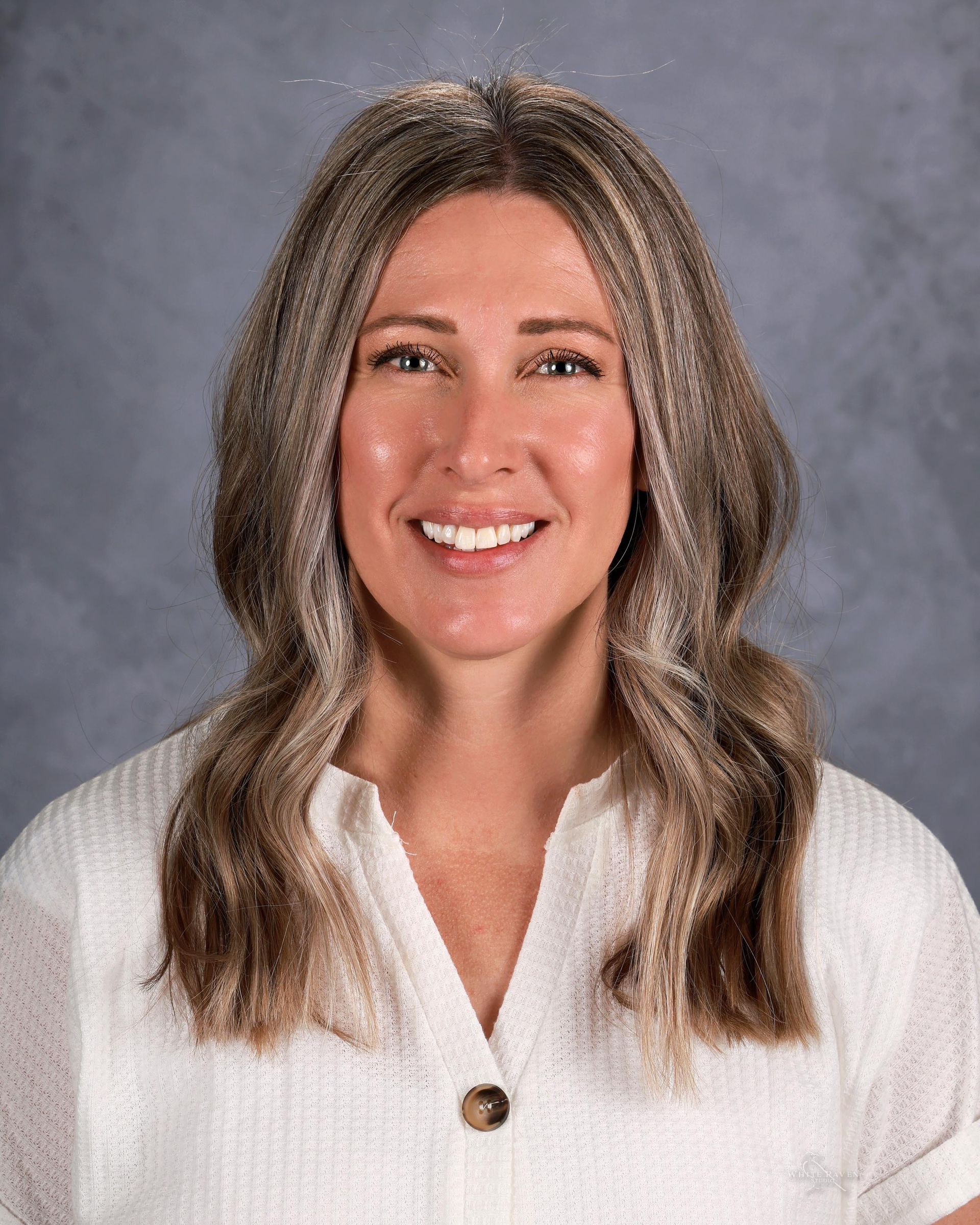 A woman in a striped shirt is smiling for the camera.