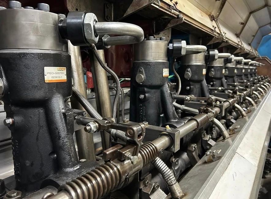 Een grote, vuile motor op een werkbank, omringd door gereedschap,reparatie in de werkplaats.