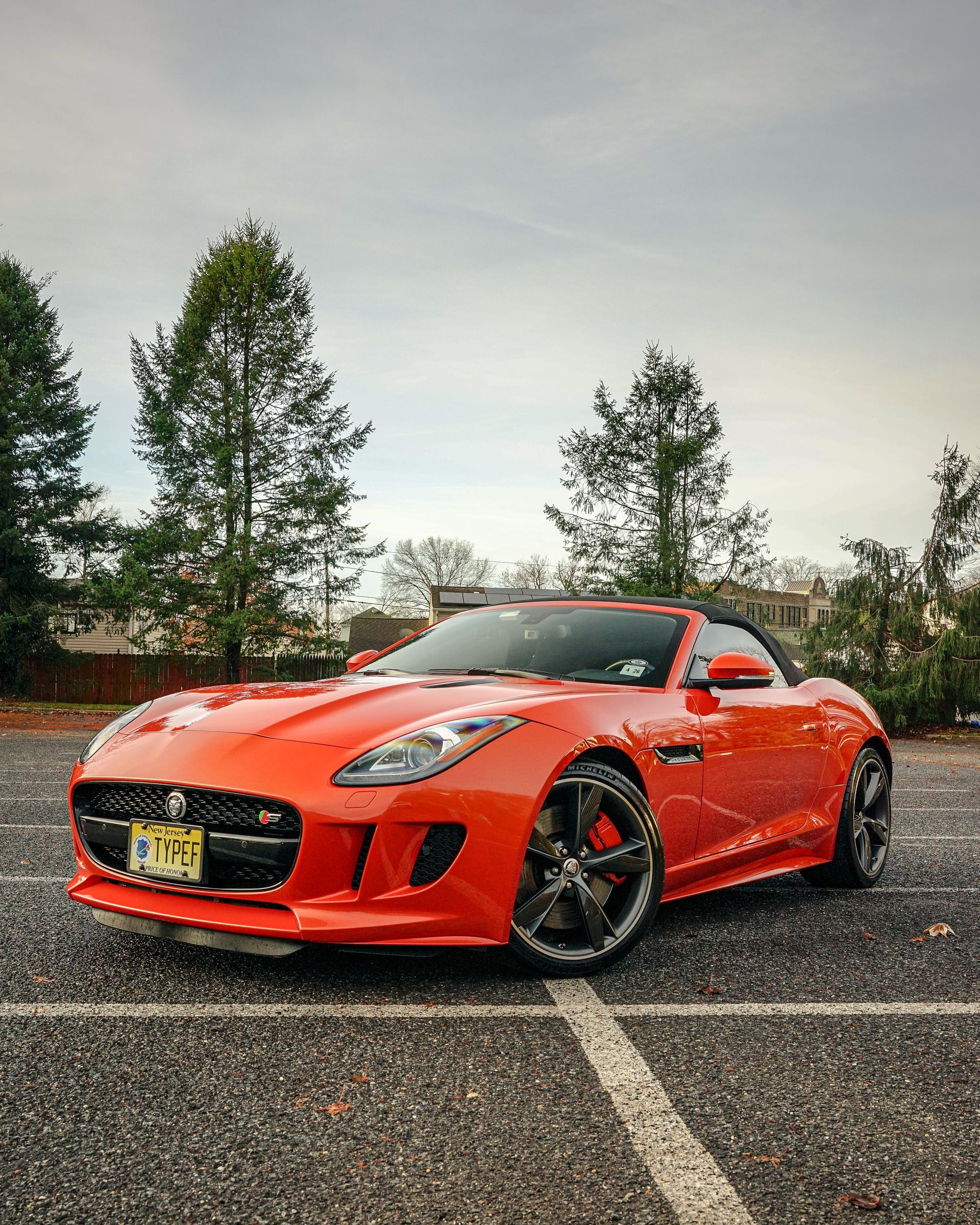 A red sports car is parked in a parking lot.