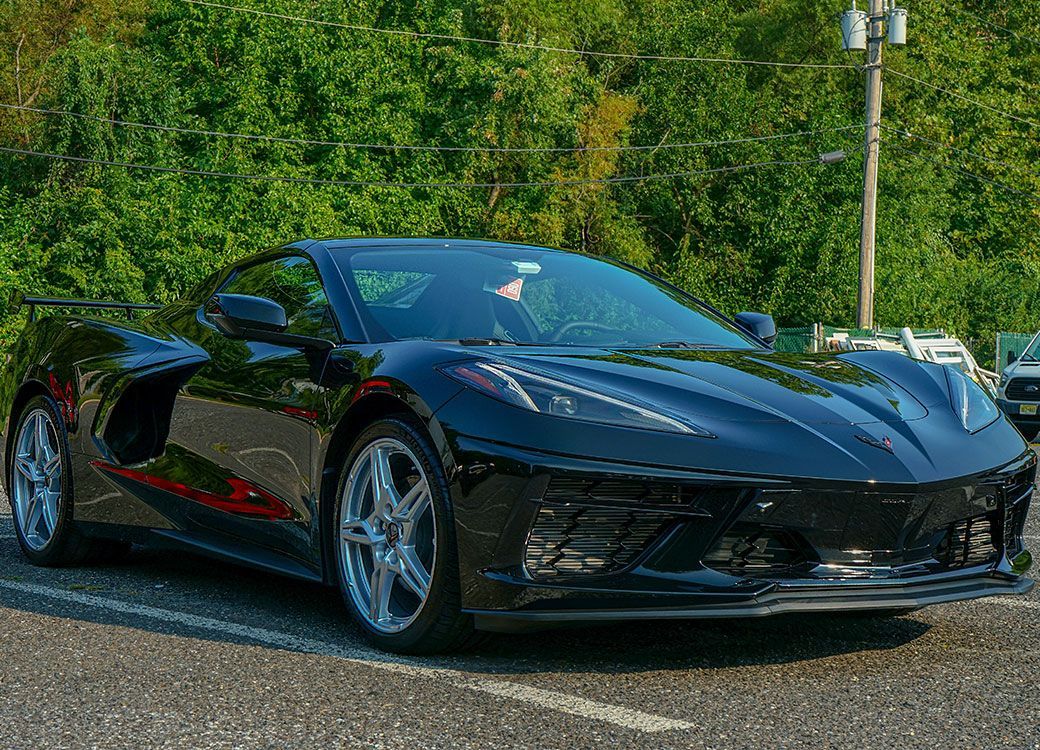 A black sports car is parked on the side of the road.