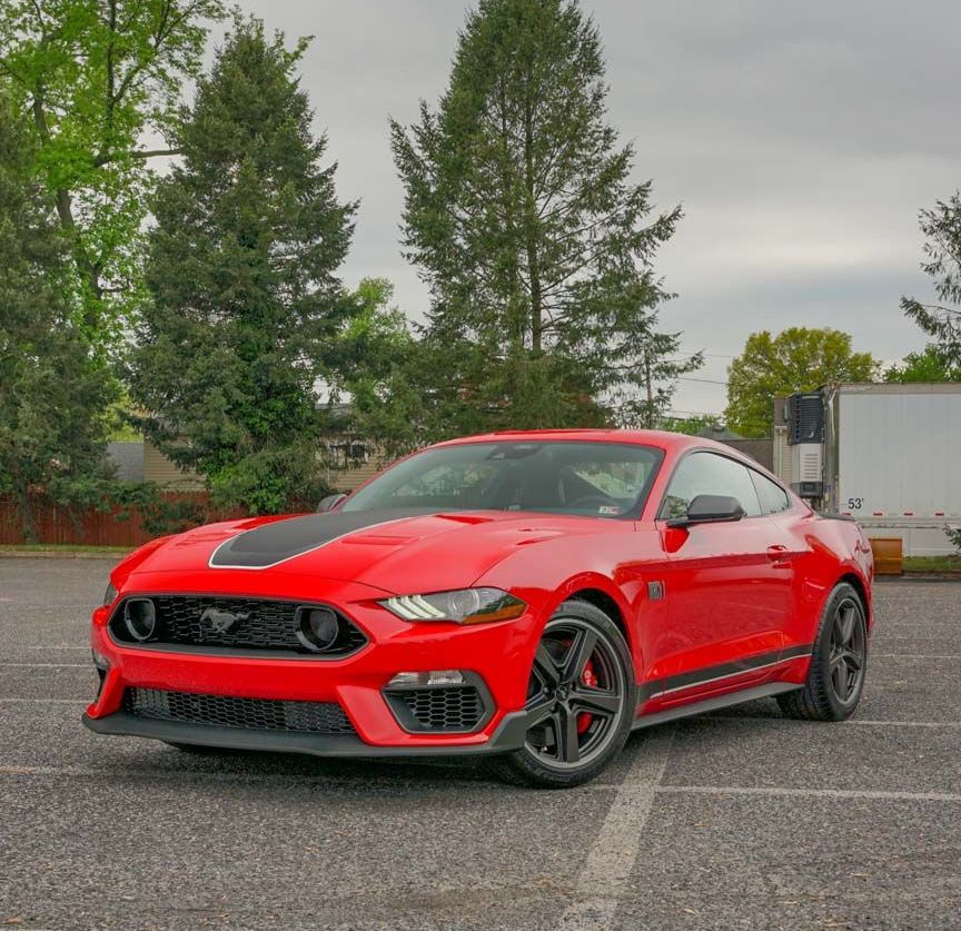 A red ford mustang is parked in a parking lot.