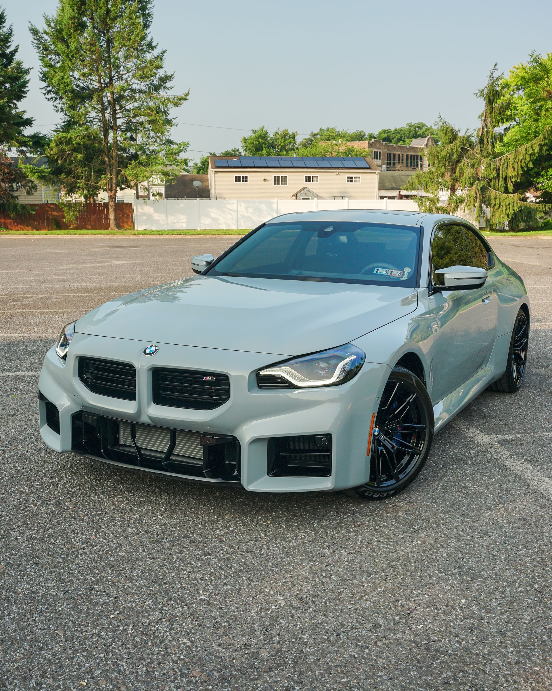 A white bmw is parked in a parking lot.