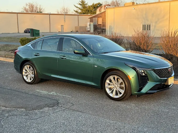 Forest green Cadillac CT5 with ceramic coating applied, highlighting rich color depth and glossy finish enhanced by ceramic coating