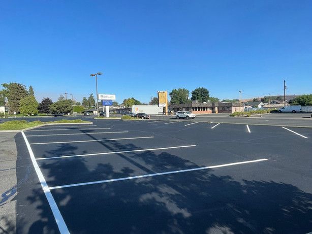 An empty parking lot with a building in the background