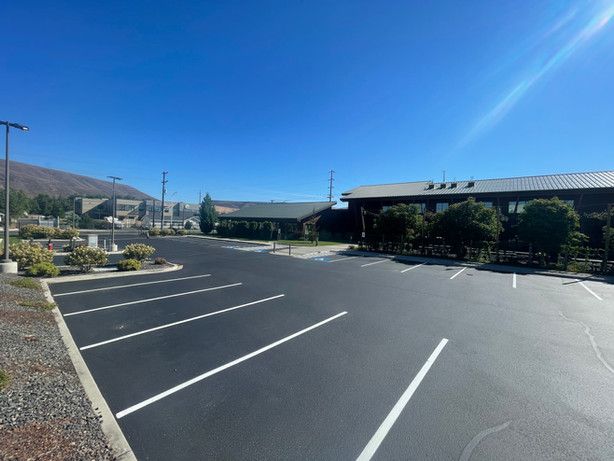 A parking lot with a building in the background on a sunny day
