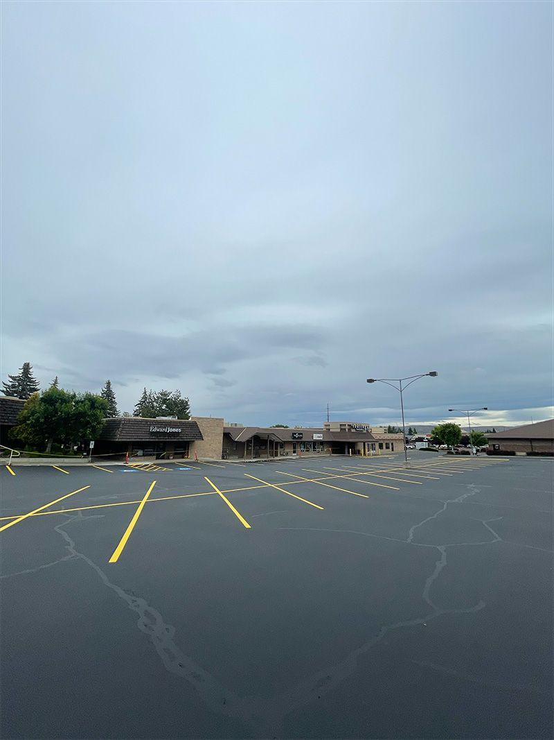 A parking lot with a few buildings in the background