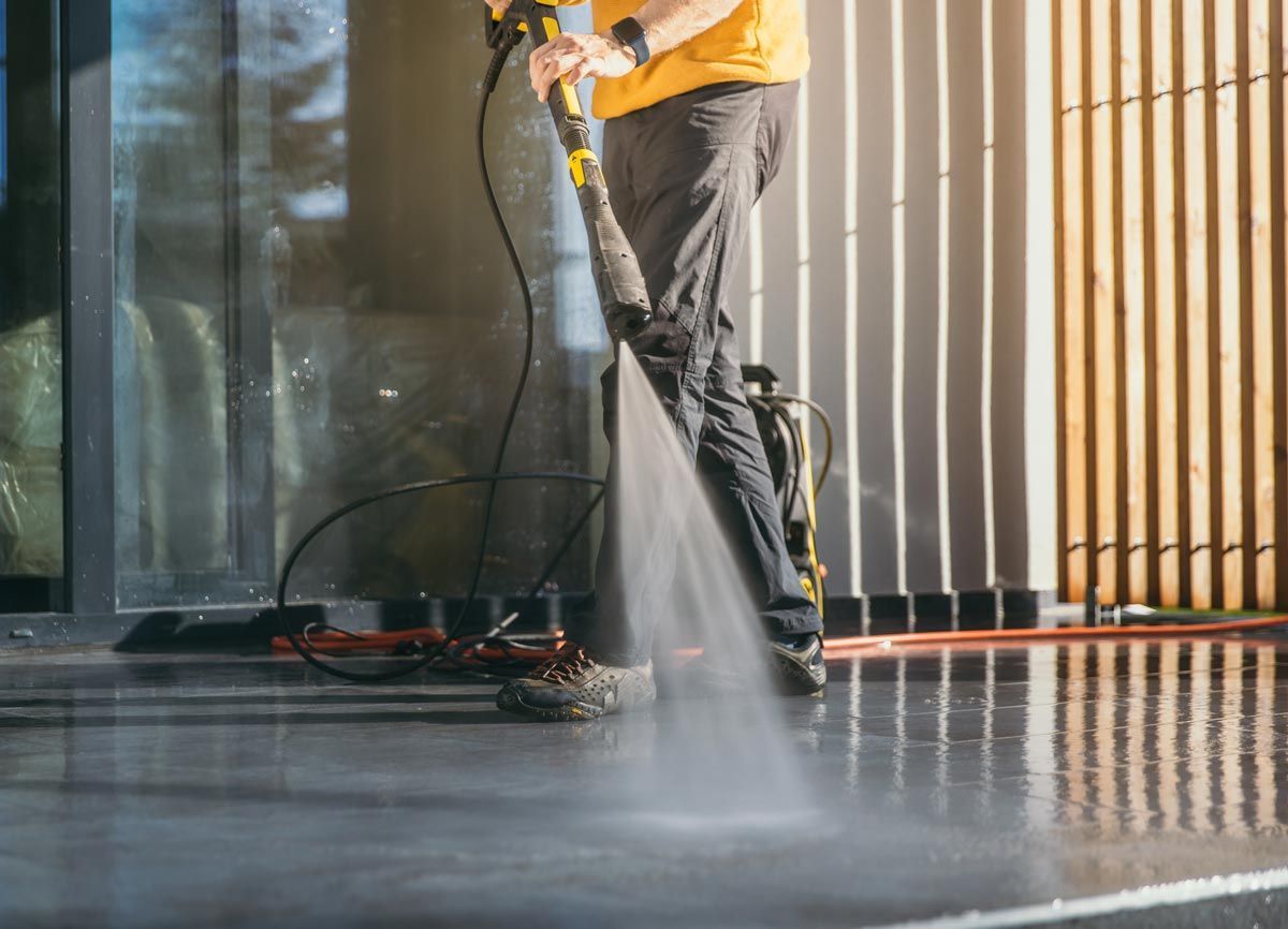 A person is using a steam mop to clean a rug in a living room.