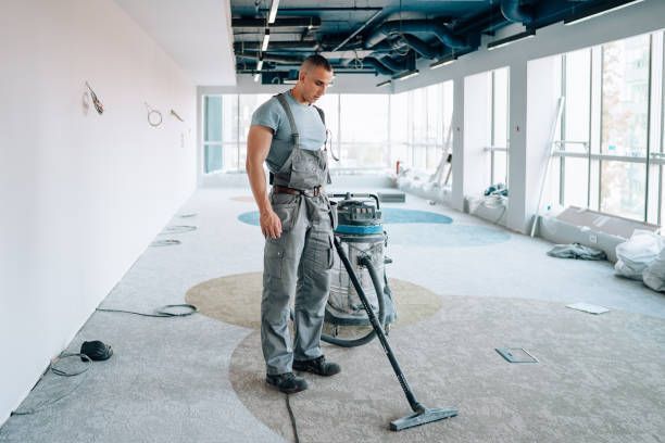 A man is cleaning the floor with a vacuum cleaner.