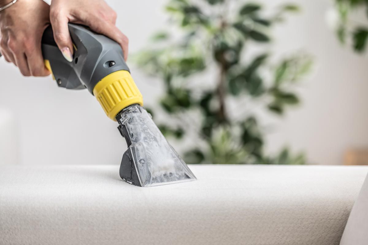A vacuum cleaner is sitting on top of a gray carpet.