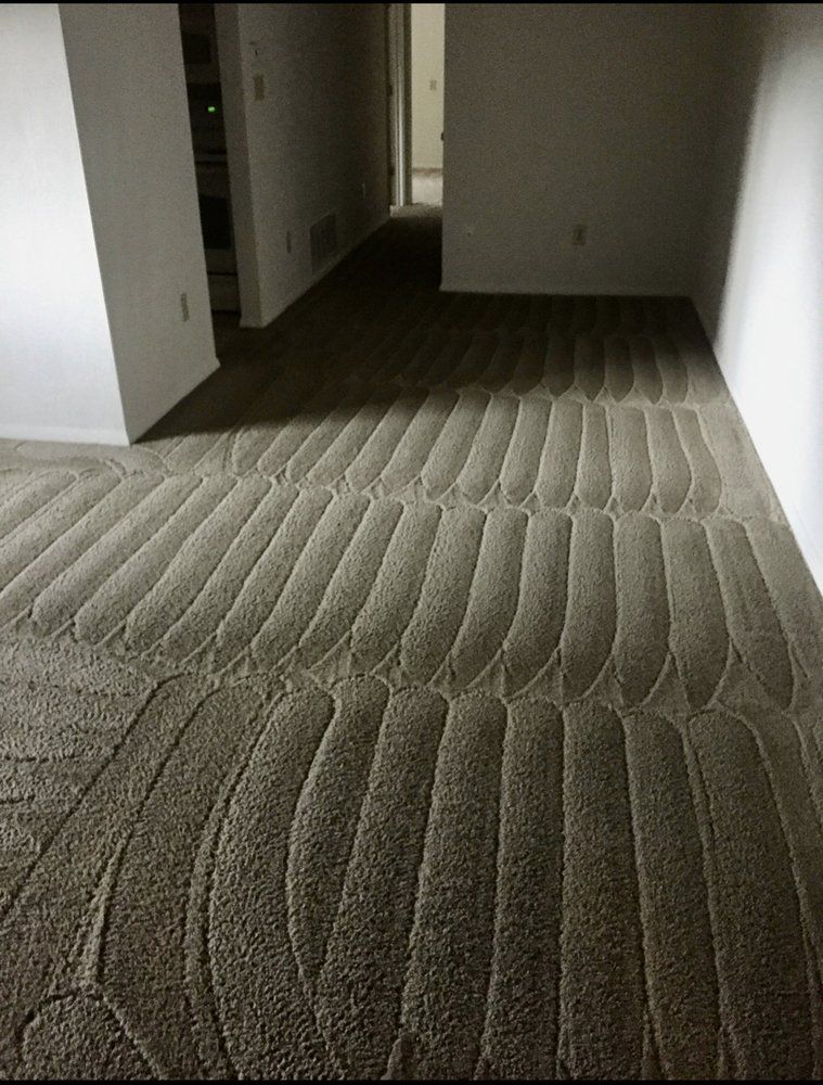 A room with a carpeted floor and a white wall