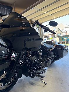 A black motorcycle is parked in a garage.