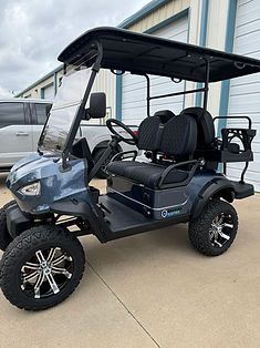A golf cart is parked in front of a garage.