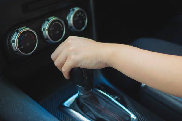 A person is changing gears in a car.