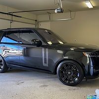 A black range rover sport is parked in a garage.