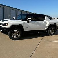 A white hummer truck is parked in a parking lot.