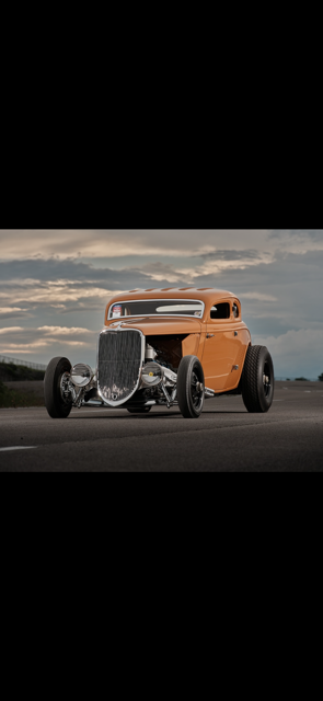 Two mechanics are working on a car in a garage.