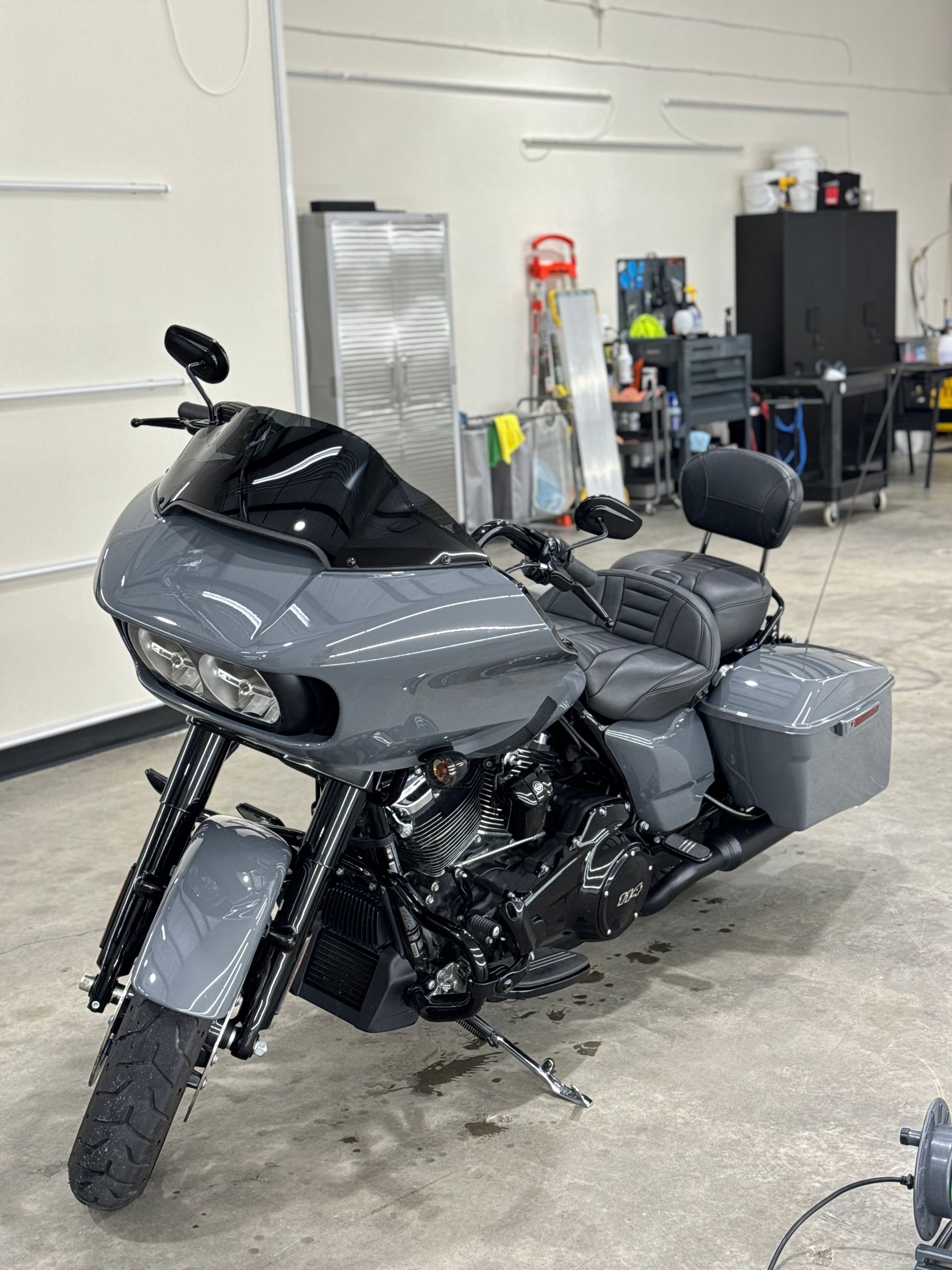 Gray Harley-Davidson Road Glide motorcycle indoors with a black windshield, seat, and engine.