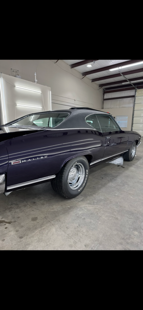 A person is applying tinted window film to a car window.
