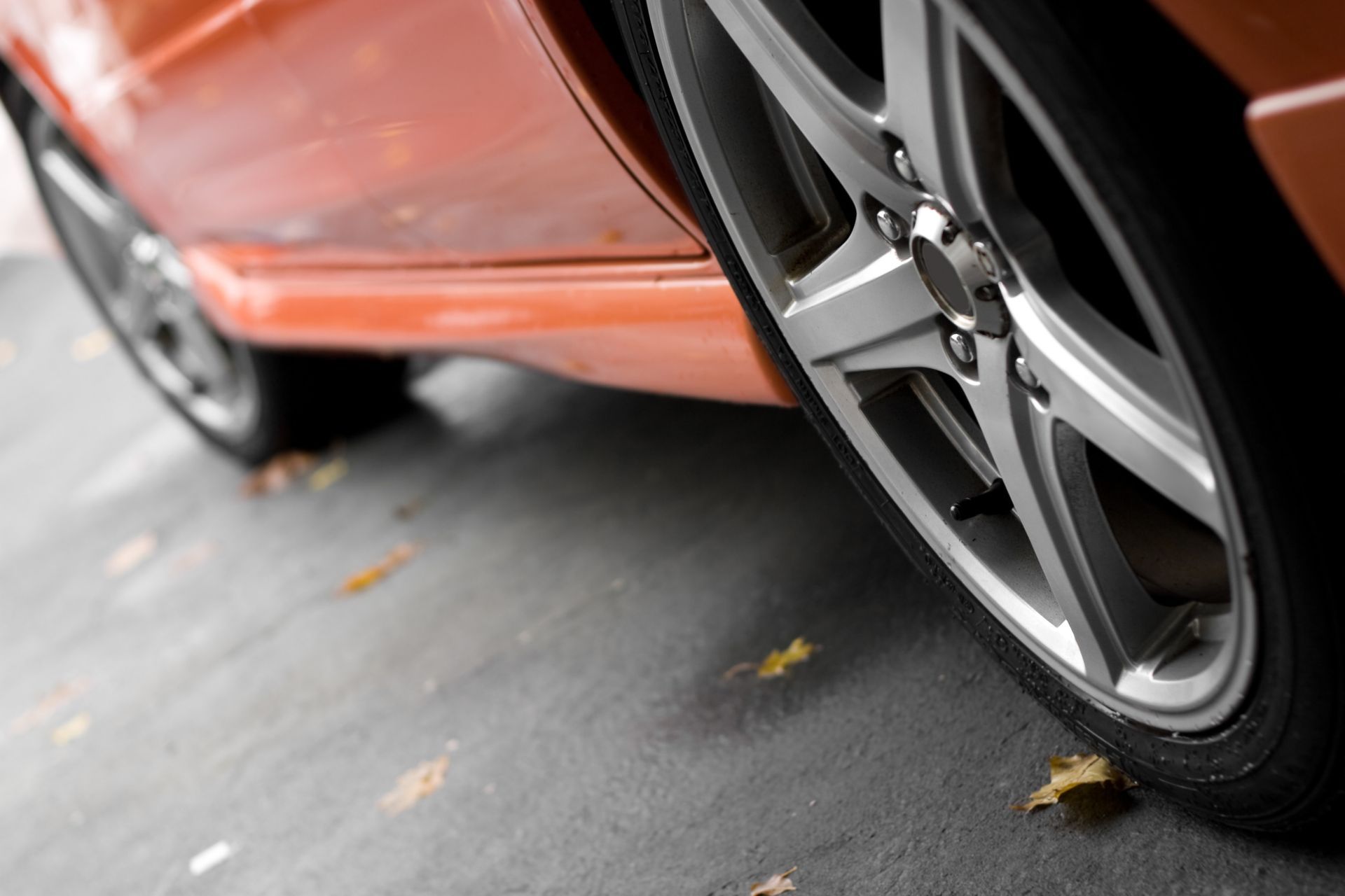 A close up of an orange car 's wheel and tire