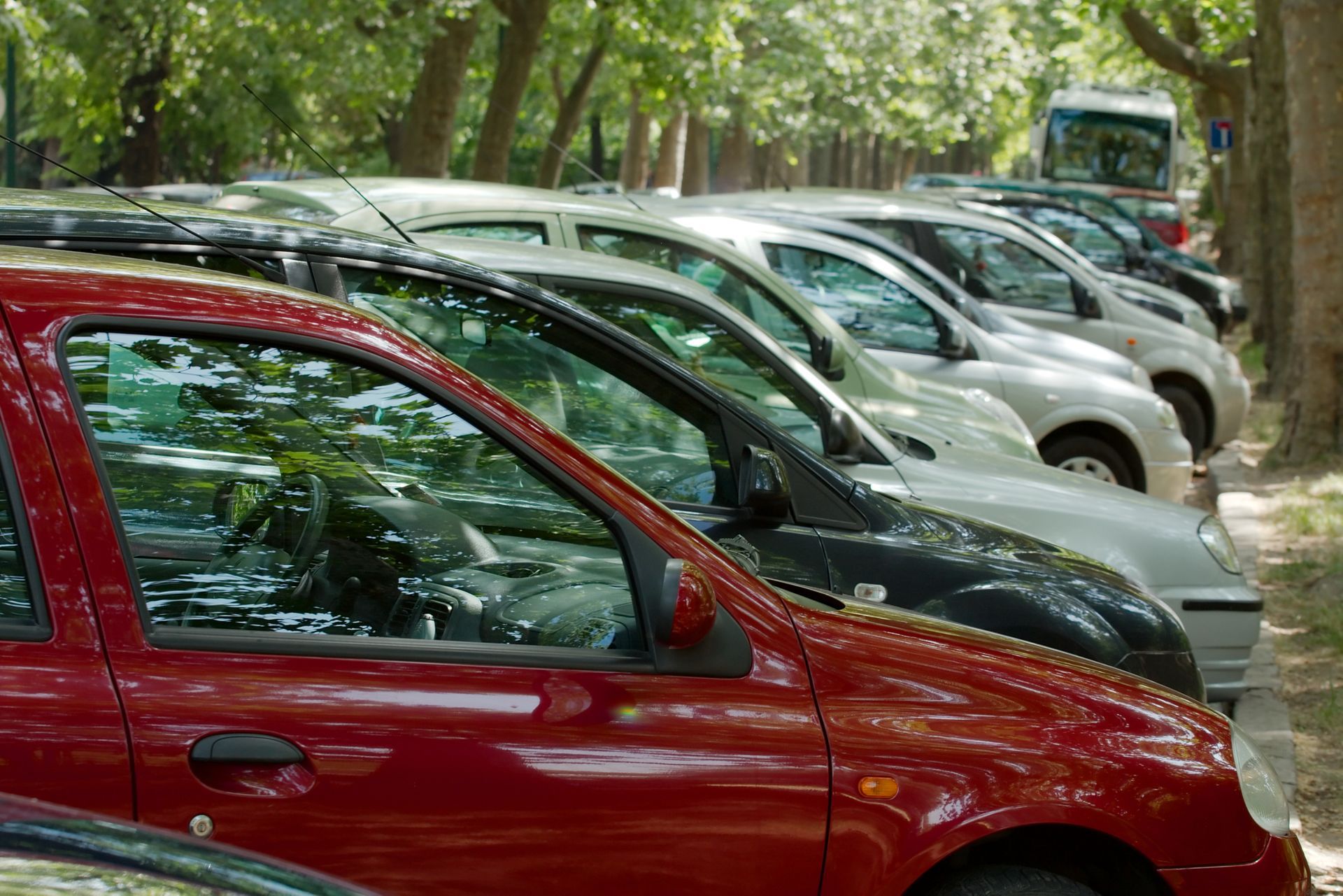 A row of cars are parked next to each other in a parking lot.