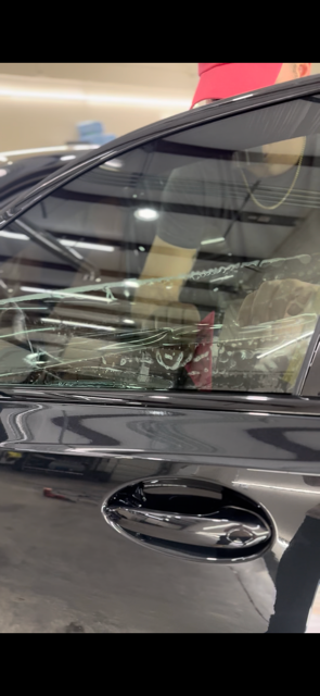 A green car is parked in a grassy field