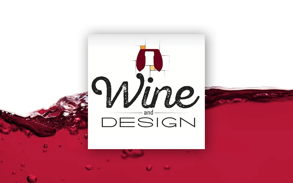 Logo for Wine and Design, featuring text on a white square over a red wine background.