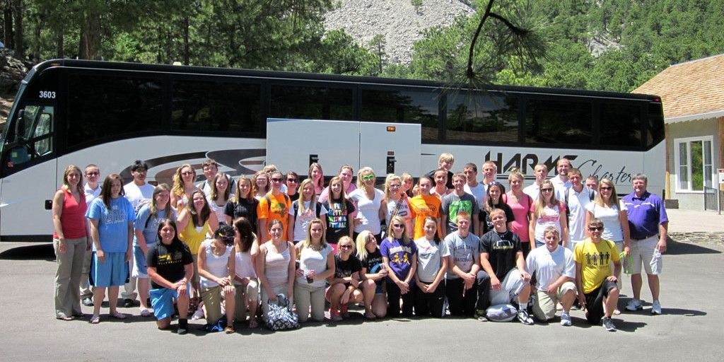 A large group of people posing in front of a bus that says market