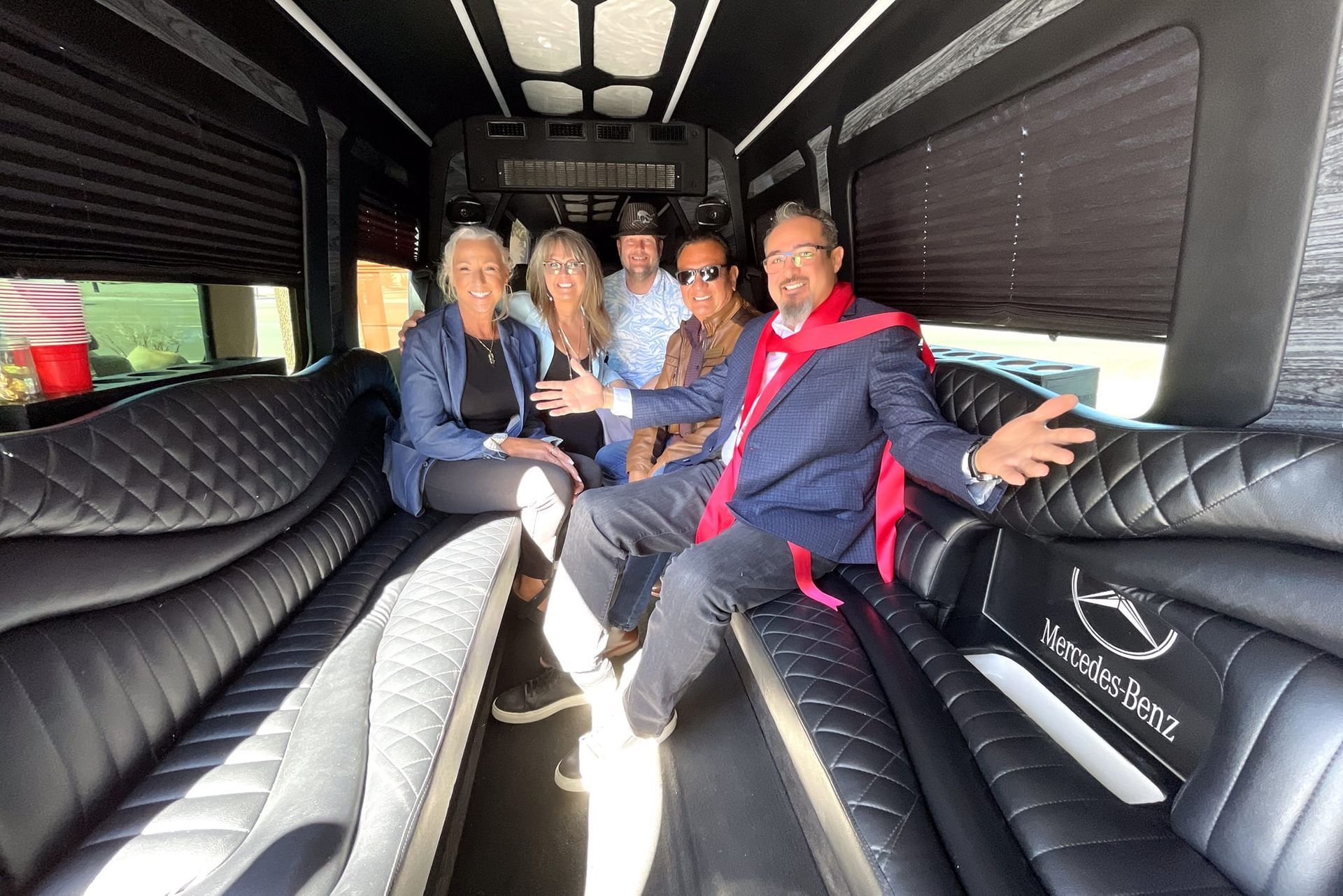 A group of people are sitting in a sprinter limousine.