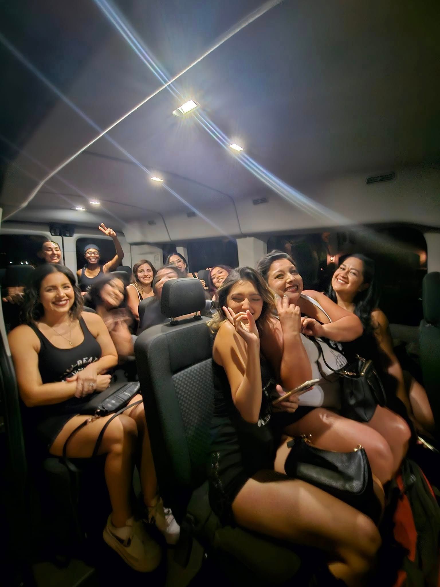 A group of women are sitting in the back seat of a sprinter .