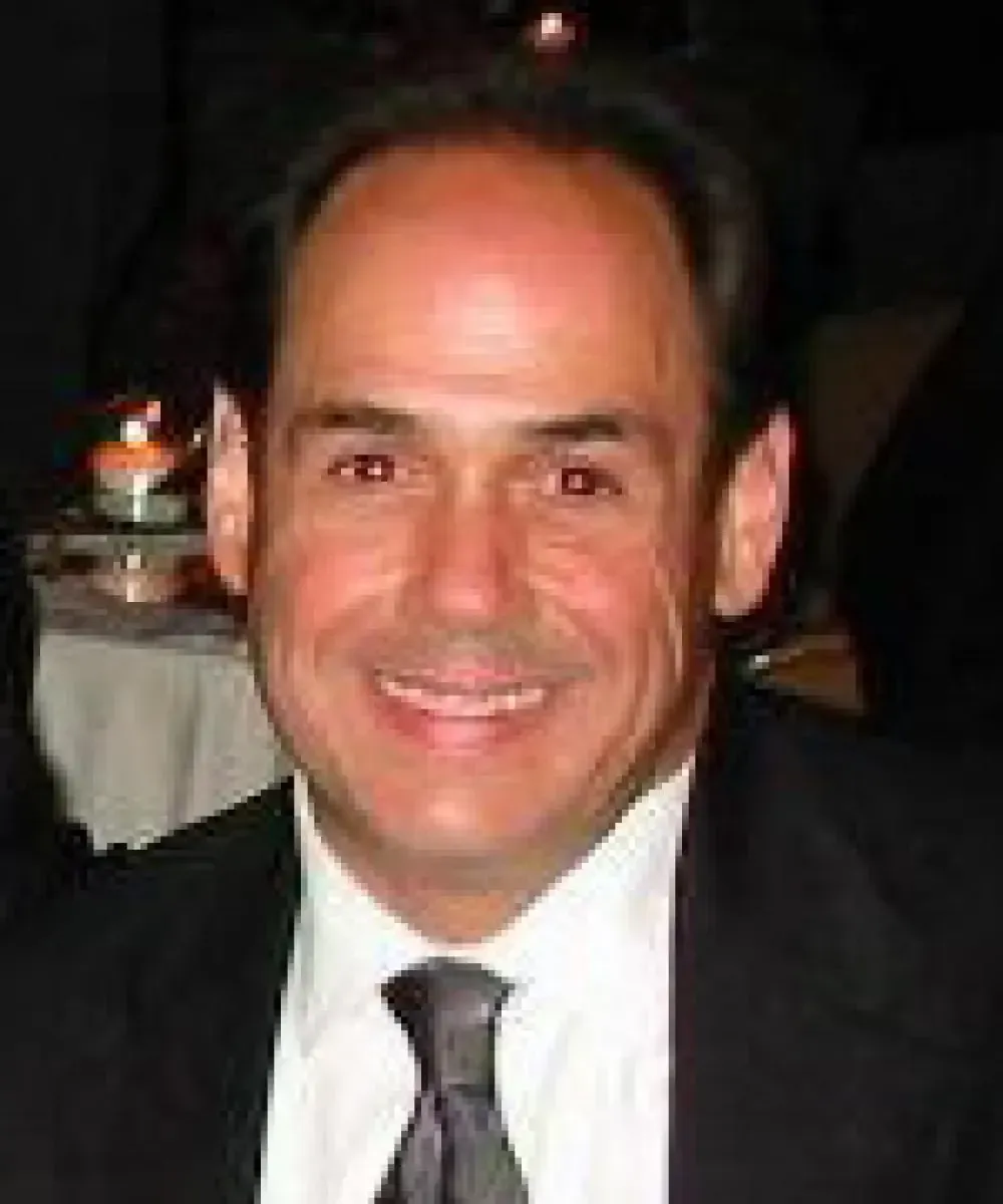 A man in a suit and tie is smiling for the camera.