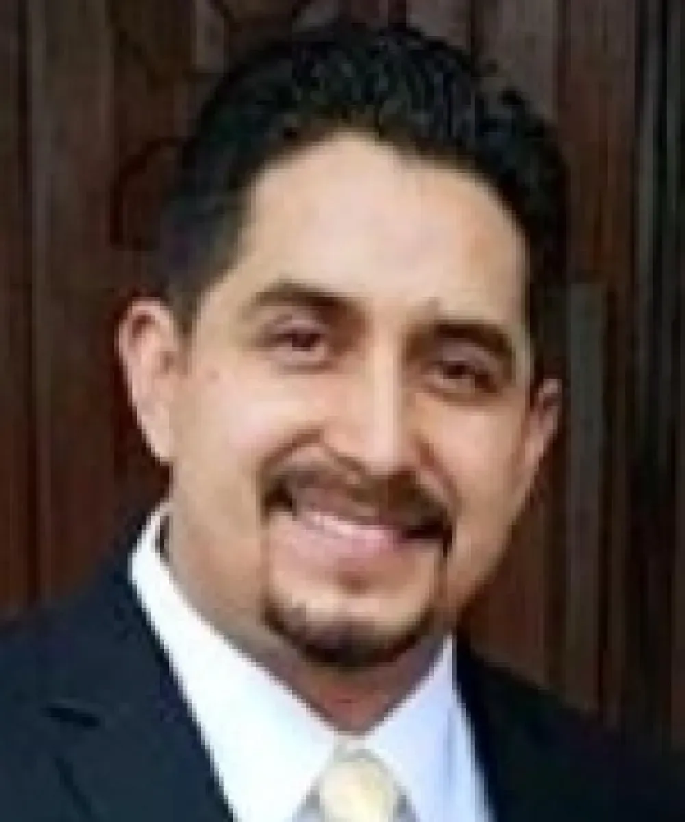 A man in a suit and tie is smiling for the camera.