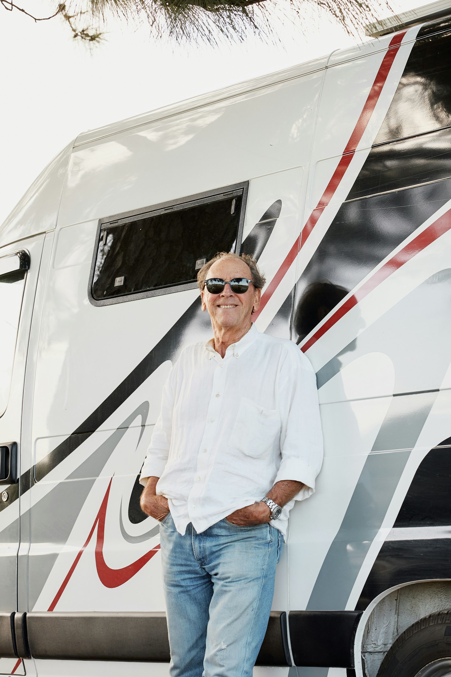 A man with a backpack is standing next to a lake in the woods.