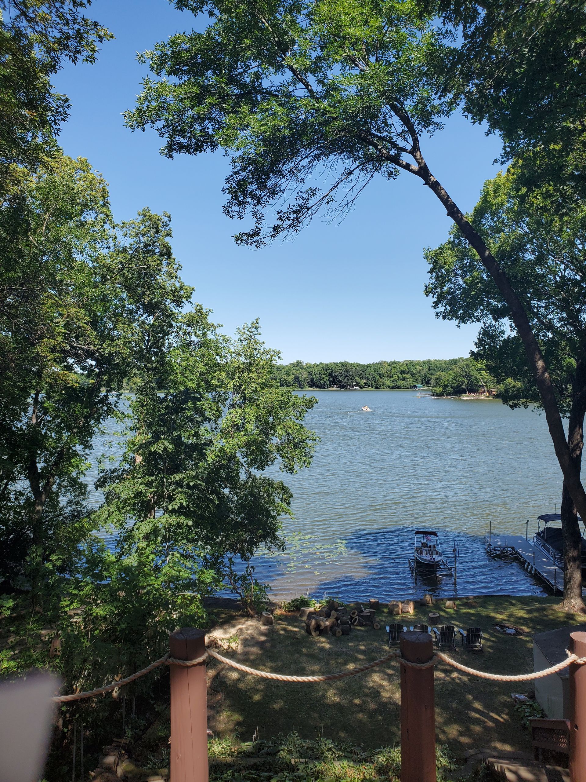 A man is cutting a tree branch with a chainsaw - Shakope, MN - Your Tree Guy, LLC